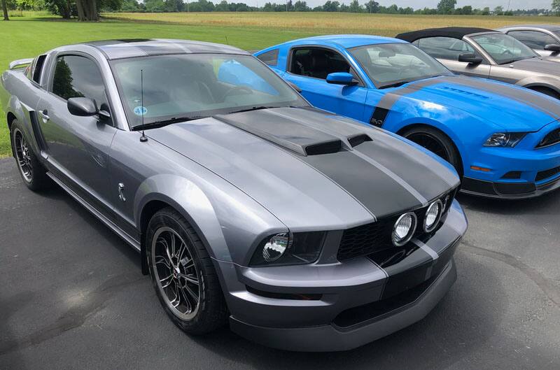 grey and blue mustangs parked in lot