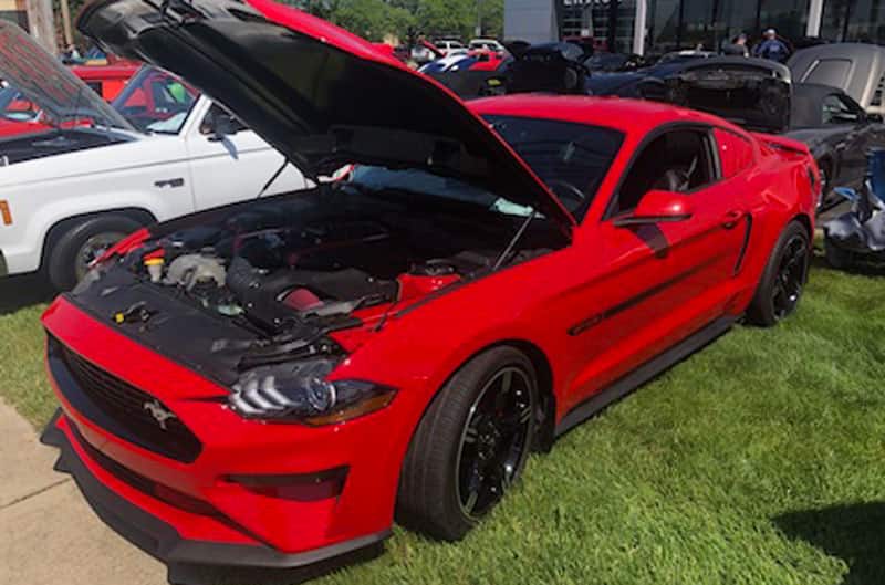 red mustang on display with hood up