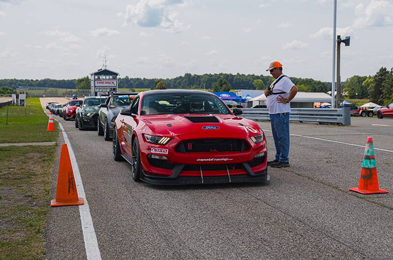 Long row of Mustangs waiting to enter track