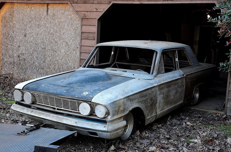 Rusted Bonner Thunderbolt half out side of garage