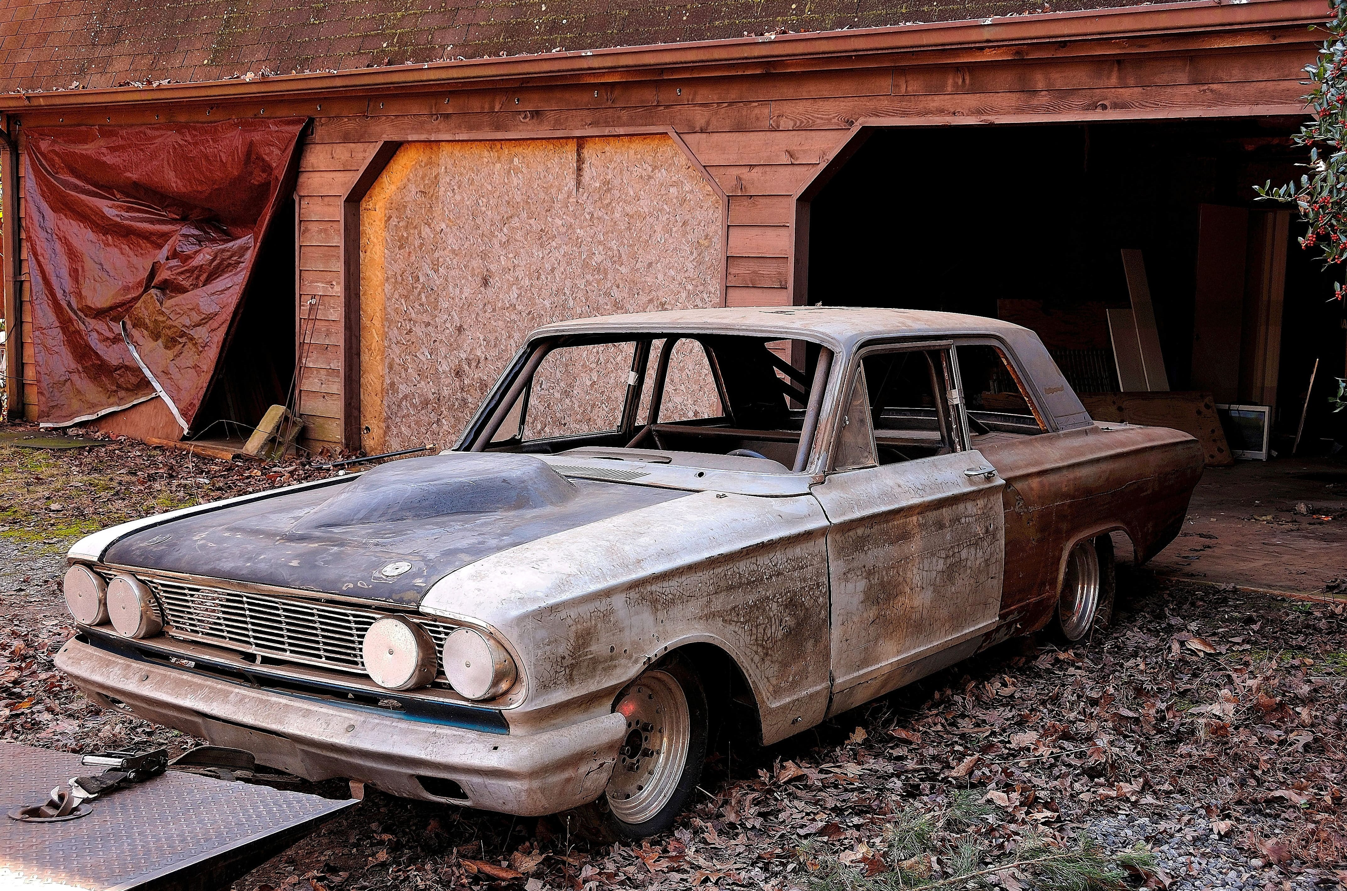 Rusted Bonner Thunderbolt in front of garage