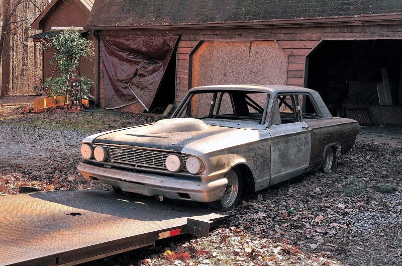 Rusted Bonner Thunderbolt in front of barn being loaded onto ramp