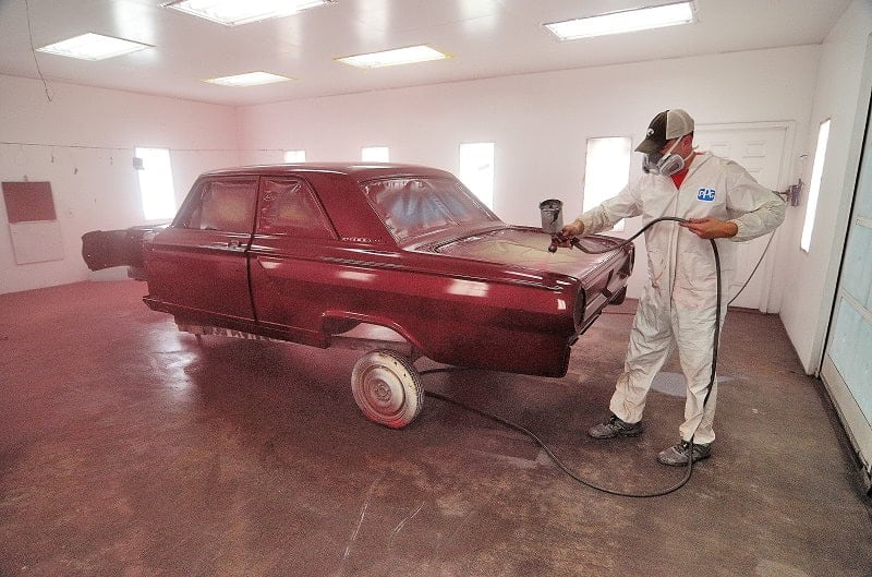 Man spray painting the body of the Bonner Thunderbolt red