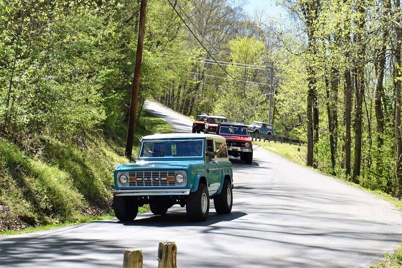 Teal Bronco leading the Bronco pack on the road