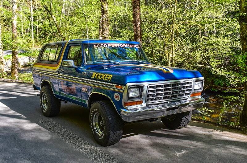 Blue Bronco with decals on forest road