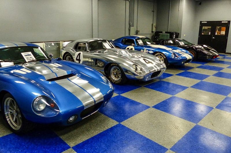 Various Shelby Cobras and GTs in garage
