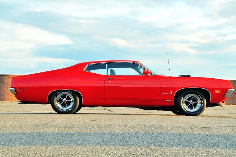 Profile of red Torino Cobra in parking lot