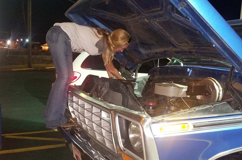 Bronco girl working under the hood of the blue Bronco