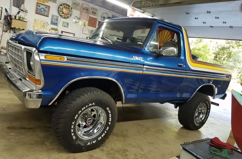 Front profile of blue Bronco with trunk hatch off in garage