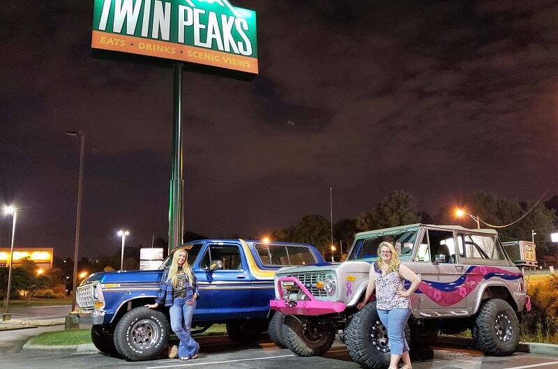 Bronco girl and friend posing with Broncos in front of Twin Peaks sign