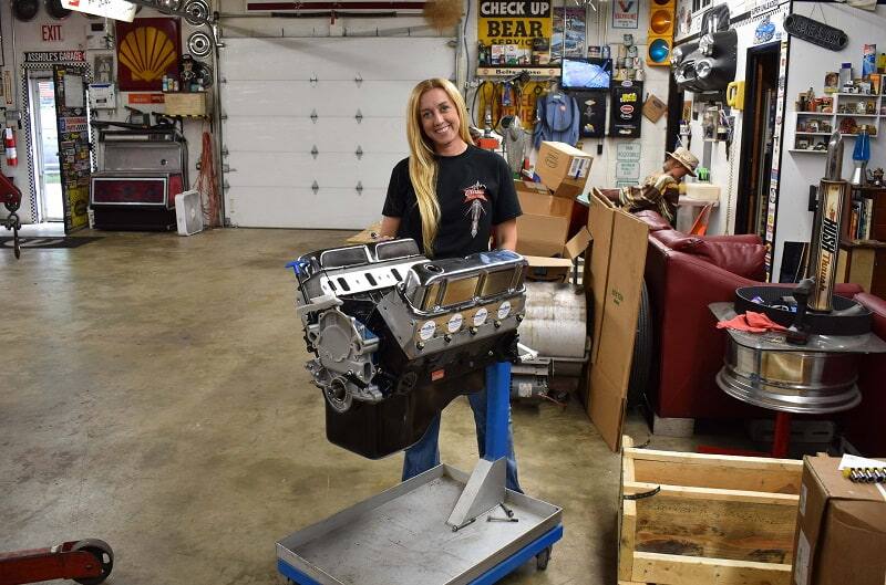 Bronco girl holding up engine in garage