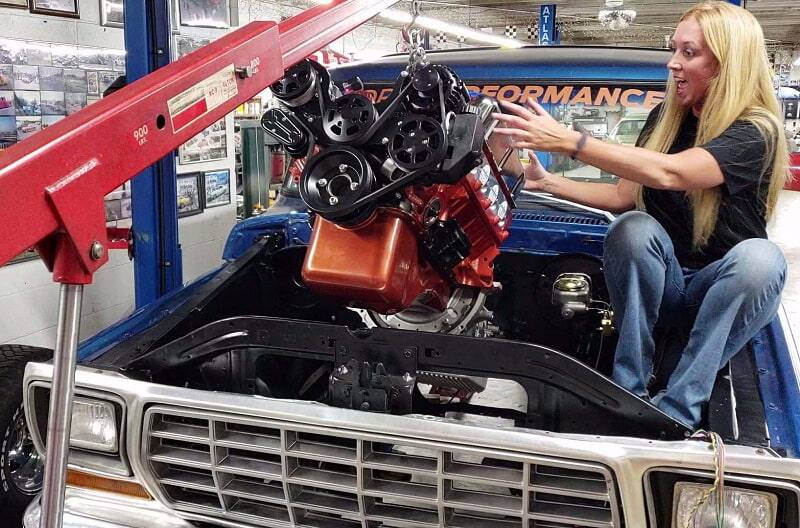 Bronco girl helping put engine in car