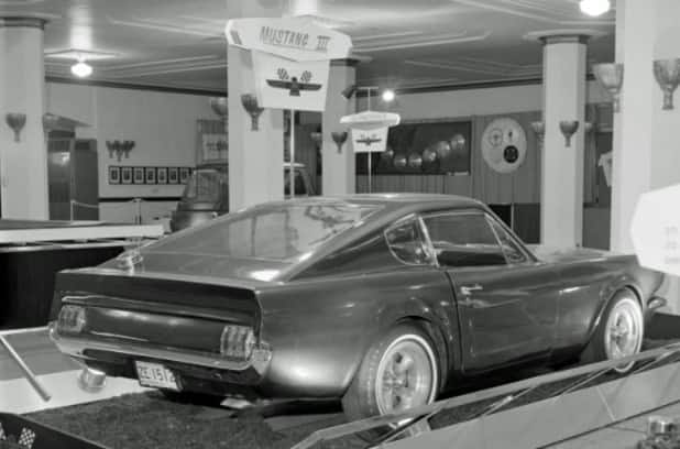 Black and white image of rear profile of Mustang on display in museum