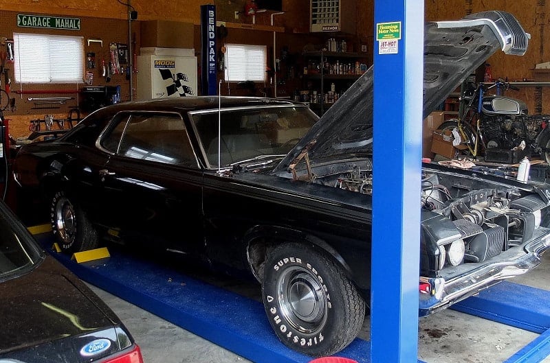 Profile of black Mercury Cougar Eliminator in garage with hood open