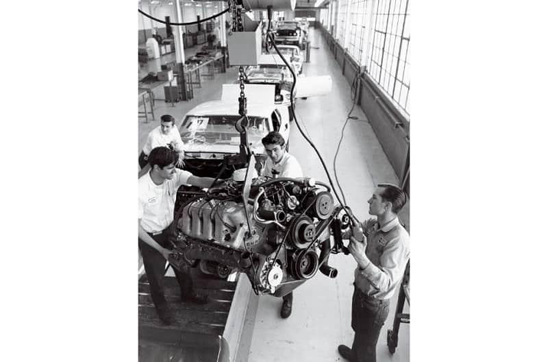 Black and white image of mechanics working on engine