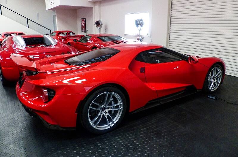 Rear profile of red GT with other red Fords behind it in garage