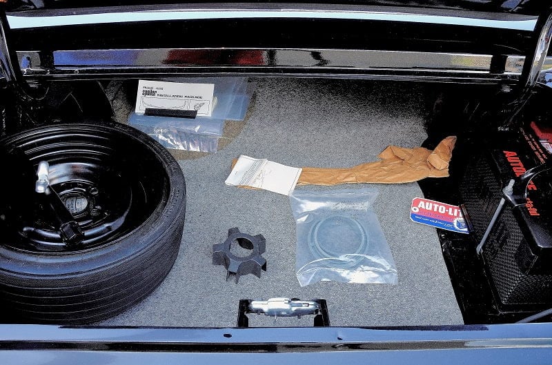 Close up of inside the trunk with extra wheel and various parts in it
