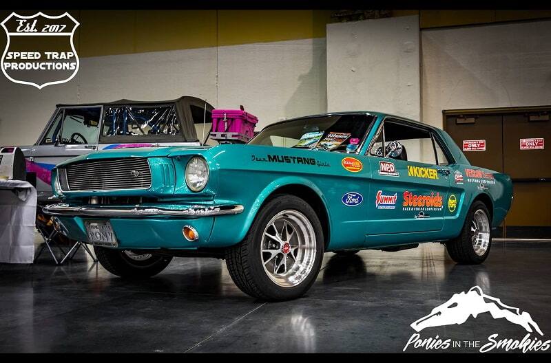 Close up of front profile of teal Mustang in a garage