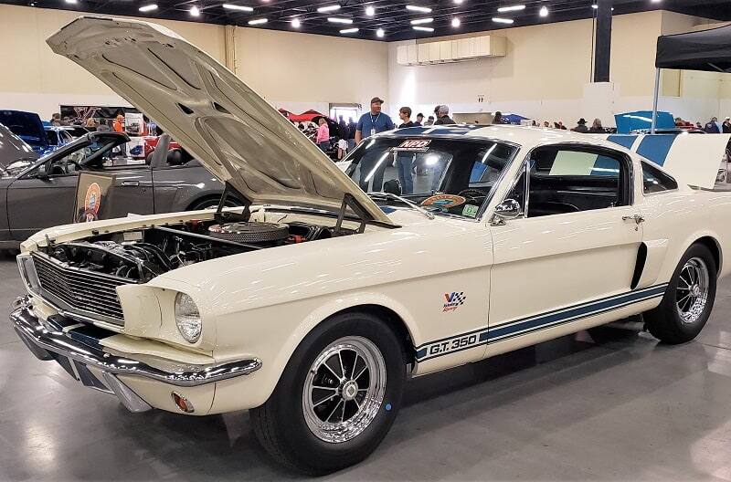 Front profile of white Mustang GT 350 with hood up in a garage