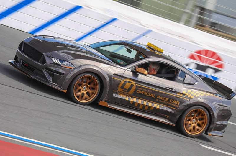 Profile of gray Mustang pace car on track driving