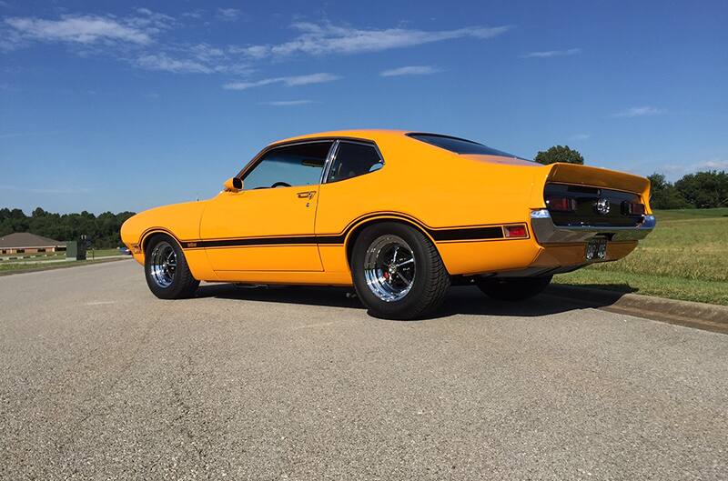 Rear profile of a yellow Maverick parked on the road
