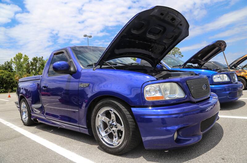 Front profile of blue SVT Lightning with hood open in parking lot