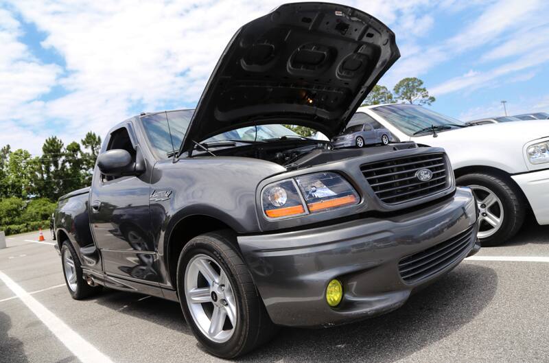 Front of gray SVT Lightning with hood open in parking lot