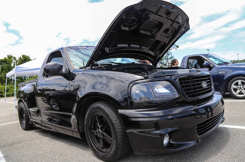 Front of black SVT Lightning with hood open in parking lot