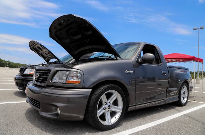 Front profile of dark gray SVT Lightning with hood open in parking lot