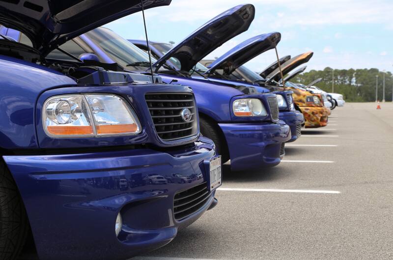 Close up profiles of front ends of various blue SVT Lightnings in parking lot