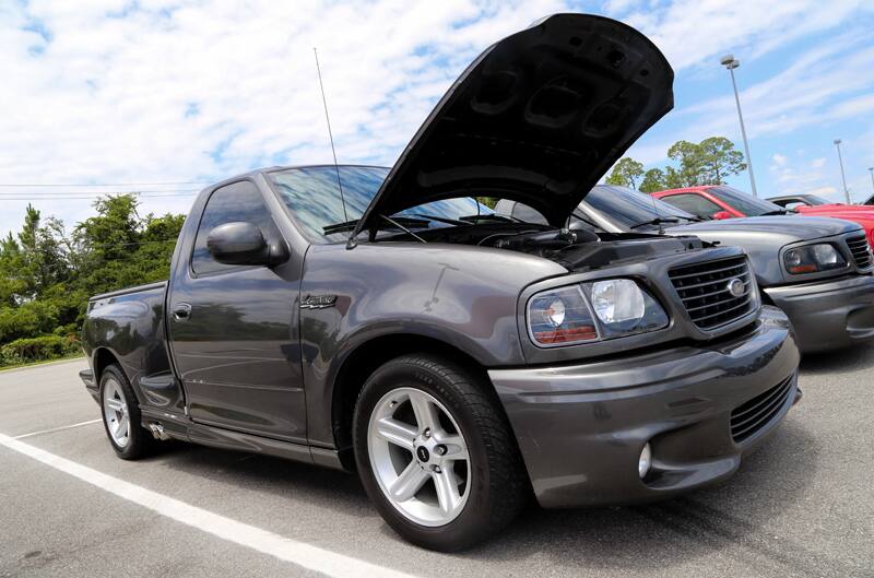 Front profile of gray SVT Lightning with hood open in parking lot