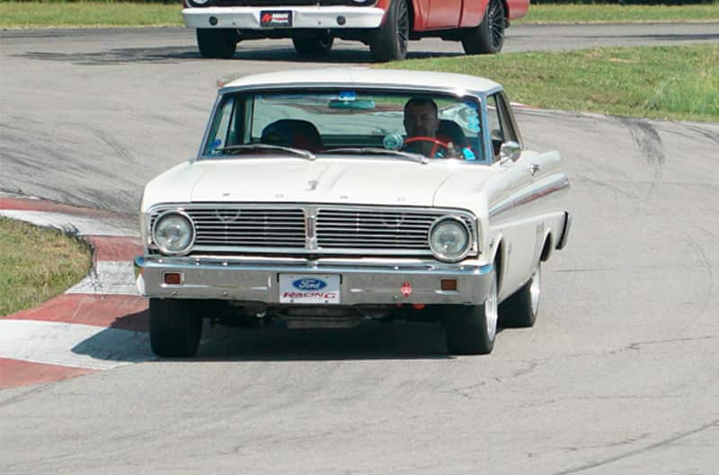 Front of white Mustang driving on the track