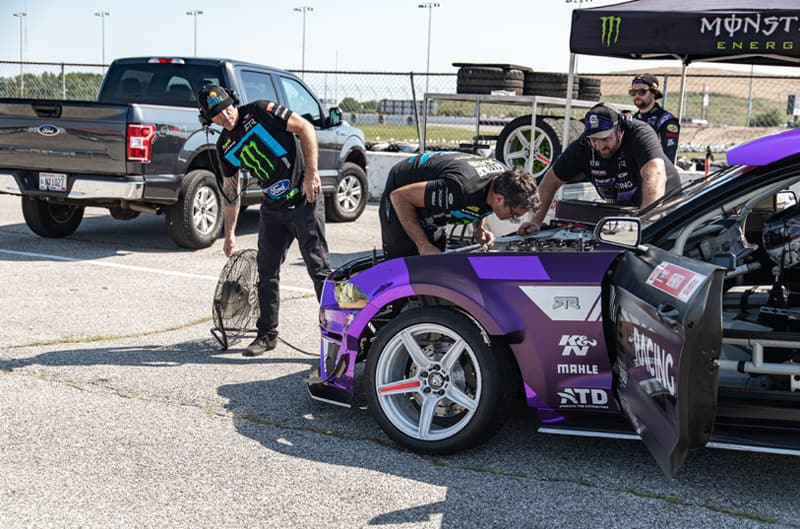 Chelsea DeNofas team working on hood of his Mustang