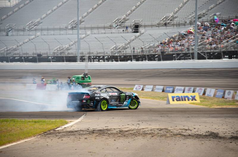 Rear profile of Vaughn Gittin Jr black Moster Energy Fun Haver Mustang drifting on the track