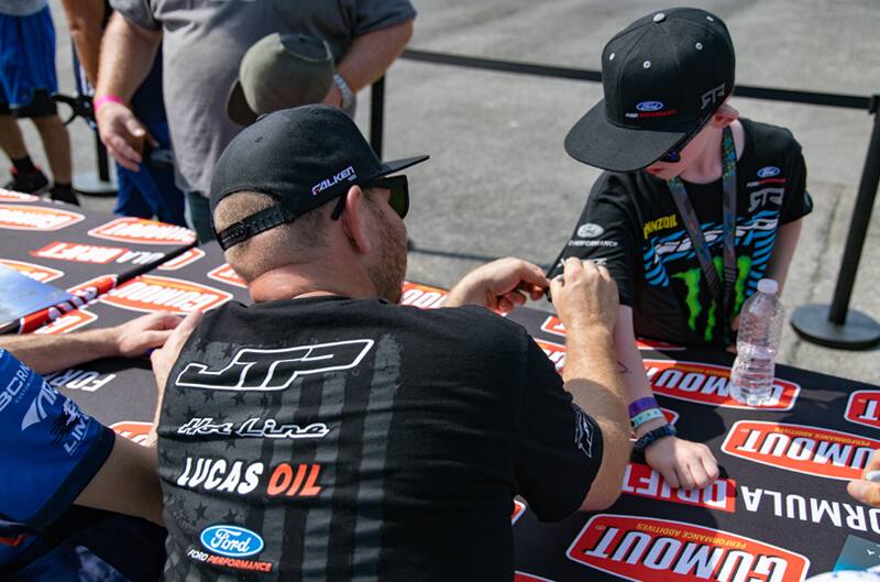 Justin Pawlak giving autograph to a young child's shirt