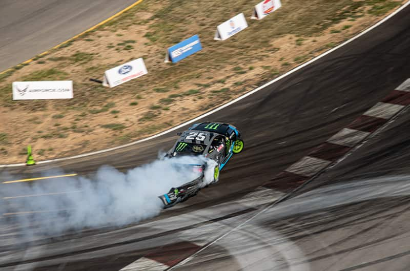 Overhead rear shot of Vaughn drifting his black Monster Energy Fun Haver Mustang on the track with the rear falling off