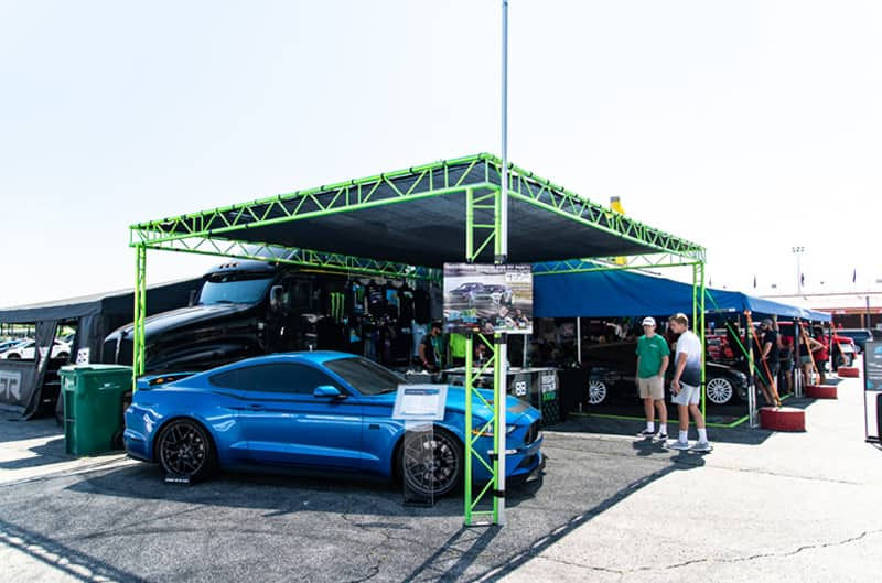 Profile of blue Mustang under a tent