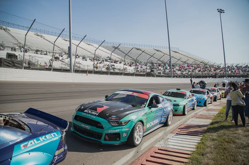 Various Mustangs in a line on the track