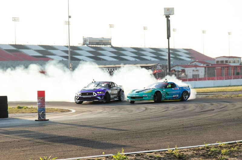 Chelsea DeNofa and Vaughn Gittin Jr drifting their Mustangs on the track