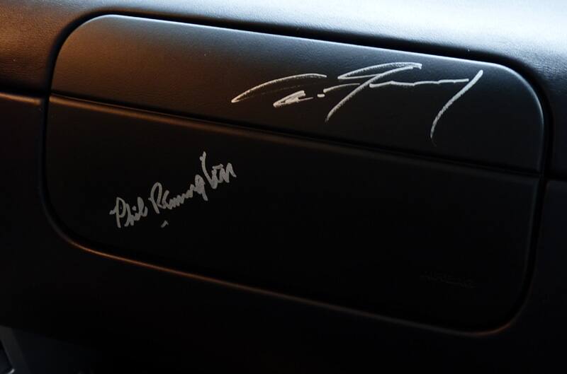 Close up of dashboard with Dan Gurney and other signature on it