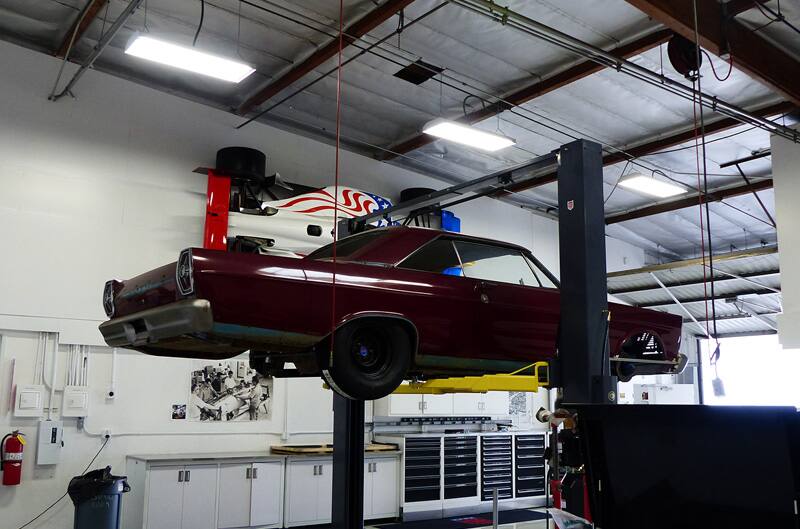 Profile of a red Galaxie lifted in a garage