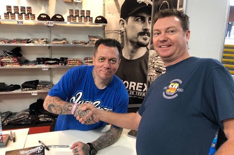 Two men shaking hands in front of a merchandise display