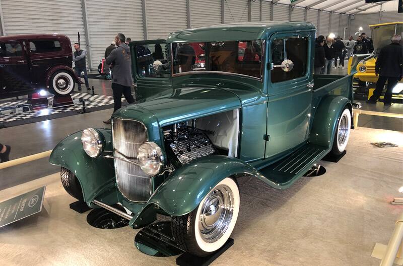 Front profile of vintage green Ford pickup on display at car show