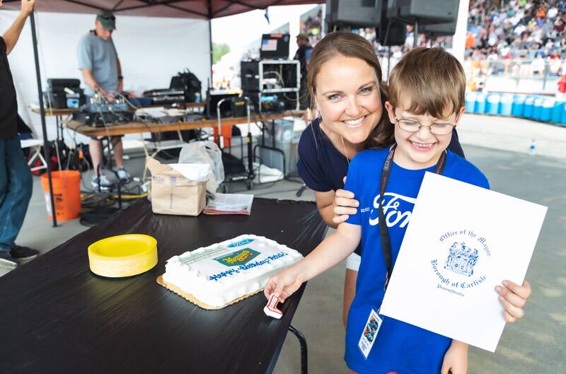 Patch Hurty posing with woman next to his cake