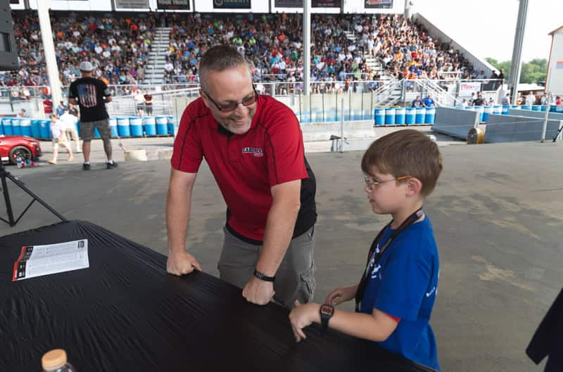 Patch Hurty standing with man at a table next to the track