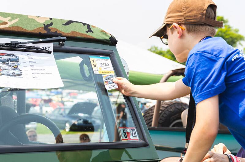 Patch Hurty putting a sticker on the window of a green Ford Bronco