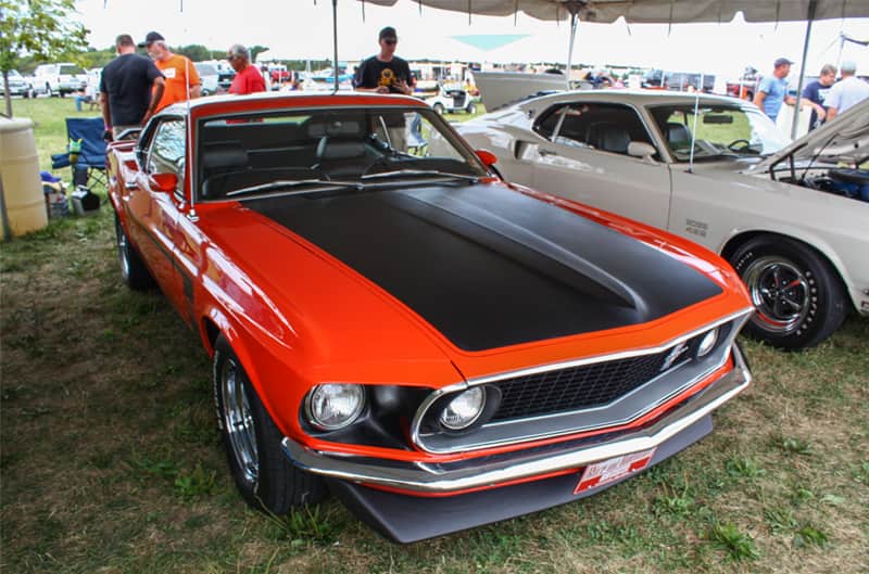 Front of red Mustang Boss with black hood parked under tent