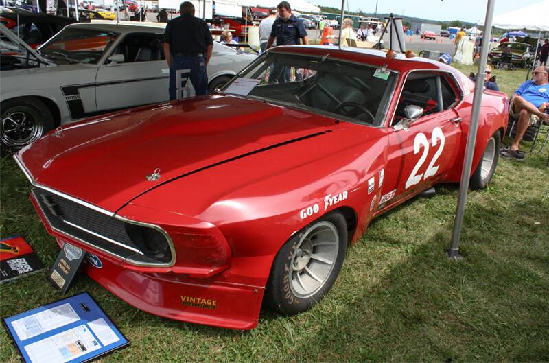 Front profile of red Mustang Boss under tent on grass