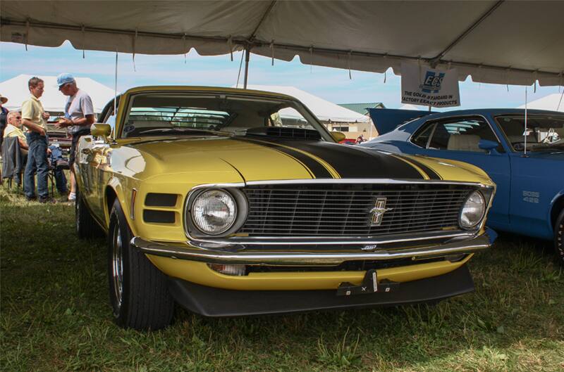 Front of yellow Mustang Boss parked under tent