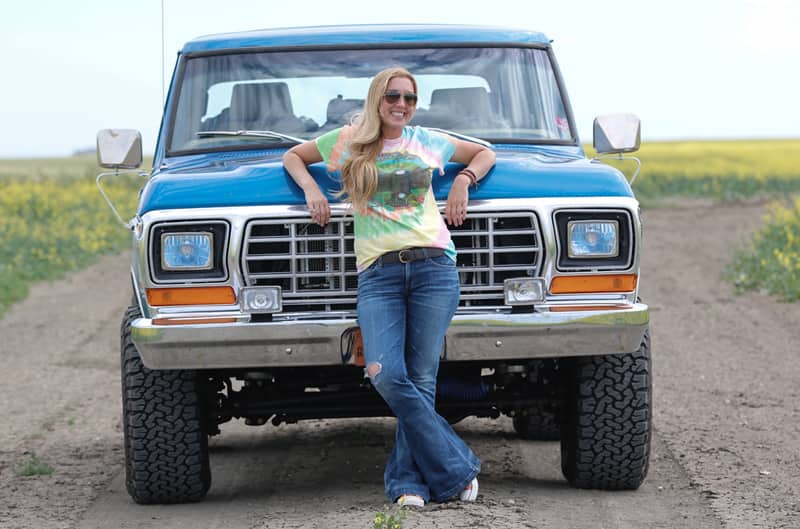 Courtney standing in front of her blue Bronco